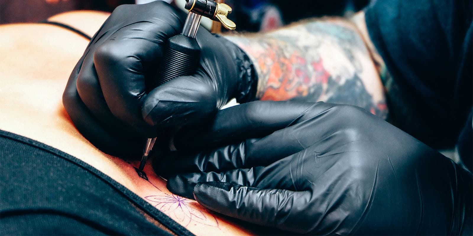 Tattoo artist preparing custom design stencil and session setup